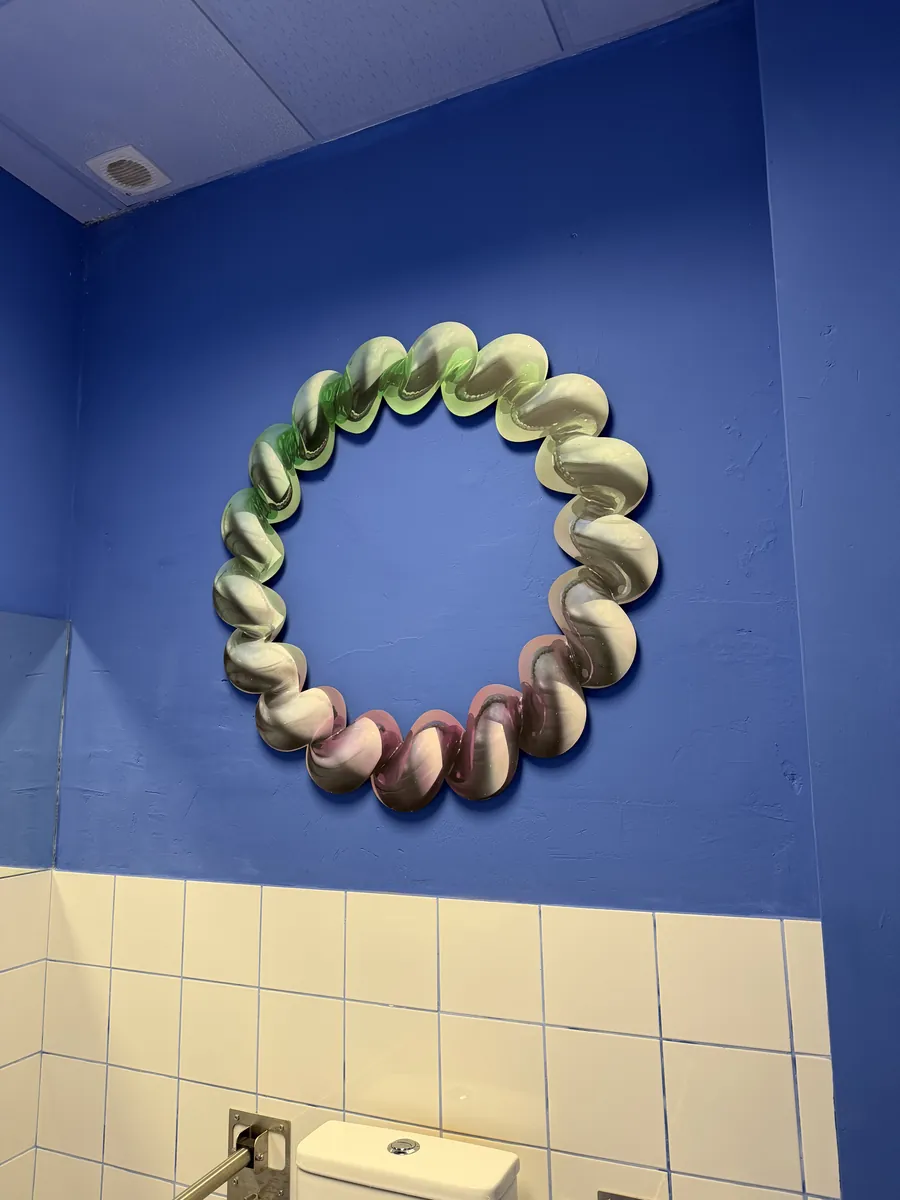 Escultura en la pared azul del baño